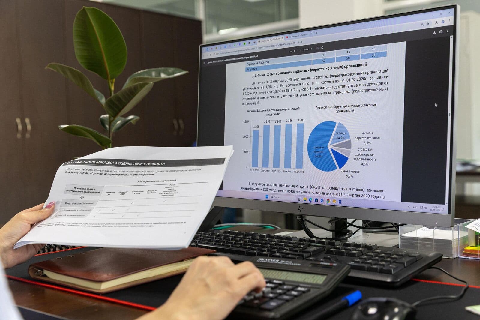 Ofiste grafik gösteren bir ekranın yanında basılı rapor